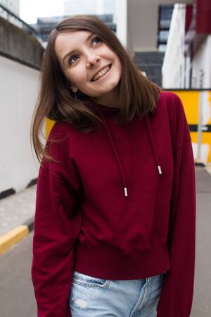 big eyes, sweet girl in burgundy hoodie, smiling and looking at youの写真素材