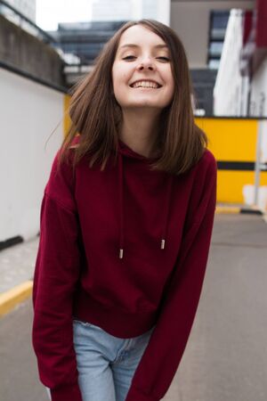 big eyes, sweet girl in burgundy hoodie, smiling and looking at youの写真素材