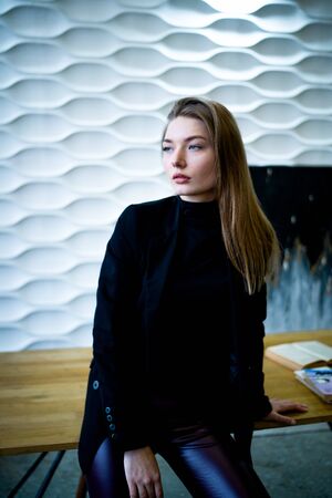Business woman standing near the table in a black jacketの写真素材