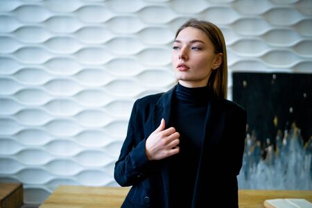 Business woman standing near the table in a black jacketの写真素材