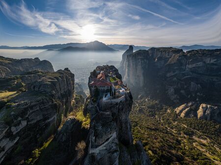 Aerial view of monastery Trinity and breathtaking pictures of valley and landmark canyon of Meteora at sunset, Kalambaka, Greece, shadows, twisted road, bridge, Mountains as columnsの写真素材