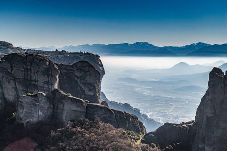 Aerial view of monument Meteora, the mountains, the landmark of Greek, sunny weather, fog, haze over a valleyの写真素材