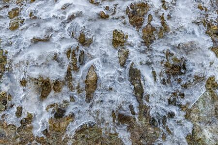 The frozen flowing-down water on a mountain slope, a glacier on a grief, ice on rocks spring thawing of iceの写真素材