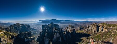 Kalambaka, Greece,  Aerial view of monastery Varlaam and breathtaking pictures of valley and landmark canyon of Meteora at sunset, Cradle on a ropeway, shadows, twisted road, bridgeの写真素材