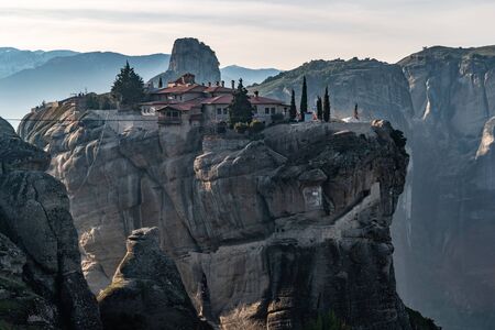 Aerial view of monastery Trinity and breathtaking pictures of valley and landmark canyon of Meteora at sunset, Kalambaka, Greece, shadows, twisted road, bridge, Mountains as columnsの写真素材