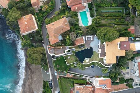 France, Saint-Jean-Cape-Ferrat, 15 December 2019: Aerial view of most expensive place in French Riviera at sunset, terraces of country houses and estates, pools, Chaise lounges, pink cloudsの写真素材