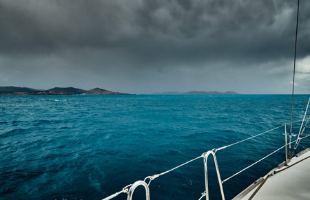 The view of the sea and mountains from the sailboat, edge of a board of the boat, slings and ropes,...