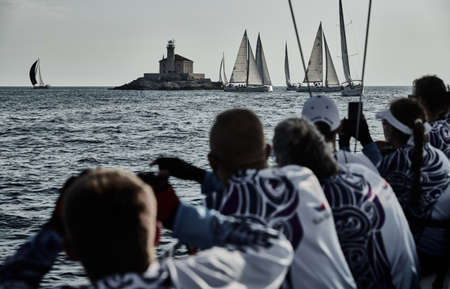 Croatia, Mediterranean Sea, 18 September 2019: Sailboats compete in a sailing regatta, The team turns off the boat, reflection of sails on water, multi-colored spinakerのeditorial素材