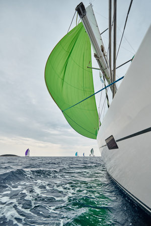 Croatia, Adriatic Sea, 19 September 2019: The race of sailboats, the team sits on the edge of a boat...