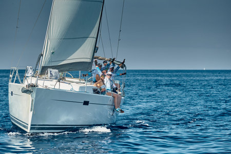 Croatia, Adriatic Sea, 17 September 2019: The race of sailboats, the team sits on the edge of a boat...