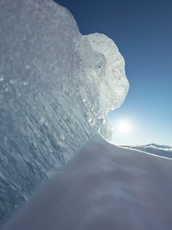 Ice slopes in sunny winter day, transparent ice of blue color, purely blue sky, long shadows, a pure...