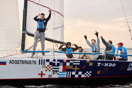 Russia, St.Petersburg, 05 September 2020: The team celebrates a victory in race, a sailing regatta on the sailboat, pull ropes, water splashes in the foreground, focus on splashesのeditorial素材