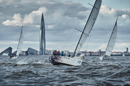 Russia, St.Petersburg, 23 July 2021: Competition of Three sailboats on the horizon in sea at sunset,...