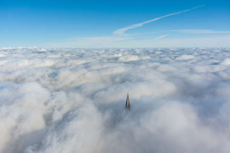 Russia, St. Petersburg, 14 October 2021: The top of the tallest skyscraper in Europe above the clouds, the building of the Gazprom oil company, the spire of a metal and glass structureのeditorial素材