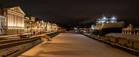 The panoramic footage of the winter night city Saint-Petersburg with picturesque reflection on water, big ship moored near Blagoveshchensky bridge, English embankment, cathedral on backgroundの写真素材