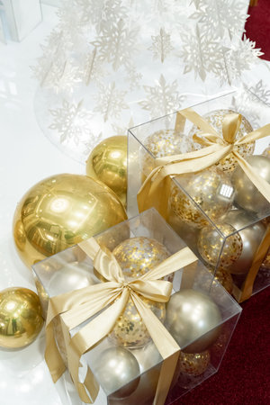 Christmas decoration in the form of gold Christmas balls in a package with a gold ribbon, white...