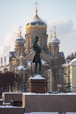 monument to the navigator Kruzenshtern in front of the Cathedral of Lieutenant Schmidt on a clear winter frosty day, golden dome and cross of churchの写真素材