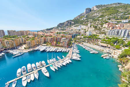 Panoramic image of Port Fontvieille - Monaco, top view from Monaco Ville, azur water, sun reflections on the water, harbour at sunny day, luxury apartments, a lot of yachts and boats, mountainの写真素材