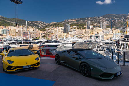 Monaco, Monte-Carlo, 27 September 2019: Two luxury sport cars Lamborghini of dark color are in port Hercules in shadow, very aggressive view of roadster, cabriolet, a lot of yachts are on backgroundのeditorial素材
