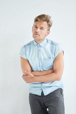 Brutal man in a shirt with short sleeves , his fists clenched, slightly bent, under the gaze of the...