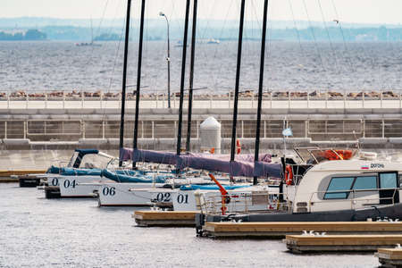 Russia, St. Petersburg, 10 June 2021: A few sailing yachts parked in a new port near the skyscraper of the gas company Gazprom at sunset, pontoons and piers, vintage wooden frigates in the backgroundのeditorial素材