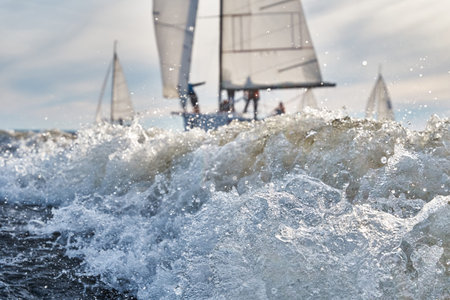 Sailing yachts in regatta at sunset, sailing regatta, hot pursuit, splashes of water, the clear sky