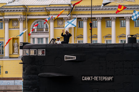 Russia, St. Petersburg, 31 July 2022: The commander of a submarine standing in the center of the city looks through binoculars, he is dressed in a festive white uniform, celebration of the day of Navyのeditorial素材