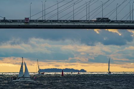 Russia, St. Petersburg, 29 July 2022: Few small sport sailing boats at sunset with stormy sky,...