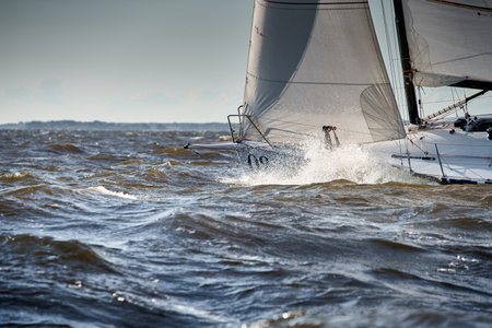 The view through the spray of how the sailboat is heeling at sunset, splashes shine in the sunの写真素材