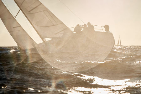 The view through the spray of how the two sailboats are heeling at sunset, boat roll, splashes shine...