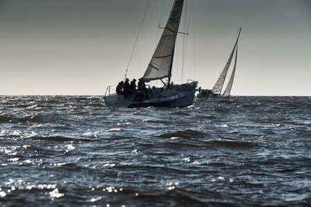 Russia, St.Petersburg, 07 July 2023: The sailing race, few boats in a roll go at high speed, sailing boats are in regatta at sunset, handsome sailors on the board of yacht, wind and splashesのeditorial素材