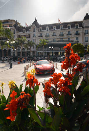 Monaco, Monte-Carlo, 22 October 2022: Square Casino Monte-Carlo at sunset, luxury cars, famous Hotel de Paris, wealth life, tourists take pictures of the landmark, pine trees, flowersのeditorial素材