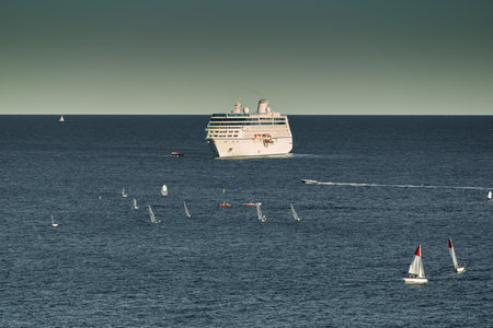 Monaco, Monte Carlo, 05 November 2022 - Mega yacht cruise ship in sea at sunset, huge motor boat, wealth life of billionaires, small sailing boats are nearbyのeditorial素材