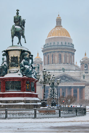 a snow-covered New Years city decorated for the celebration of the new year, the golden dome of St. Isaacs Cathedral, walking touristsの写真素材