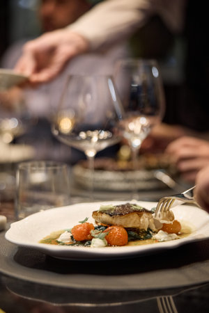 Wine glasses are on the table, stylish table setting, wine is poured from a bottle and decanter,...