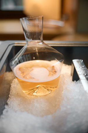 Decanter of rose champagne is cooled in a niche with ice in the restaurant, local lighting, wine cabinet, bubblesの写真素材