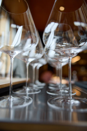Clean wine glasses are on the table, stylish table setting, ice, bottle of sparkling wine, light from windowの写真素材