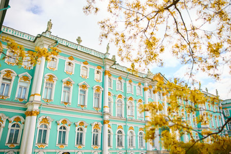 the incredibly picturesque facade of the Winter Palace through the branches of trees on a clear...