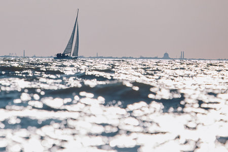 Sailing regatta in the Gulf of Finland at sunset, sailing yacht competing in a race, splashing water...