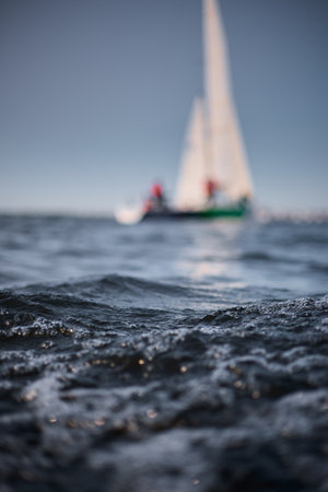 Sailing regatta in the Gulf of Finland at sunset, sailing yacht competing in a race, splashing water from under the boat, teamwork, board the boatの写真素材