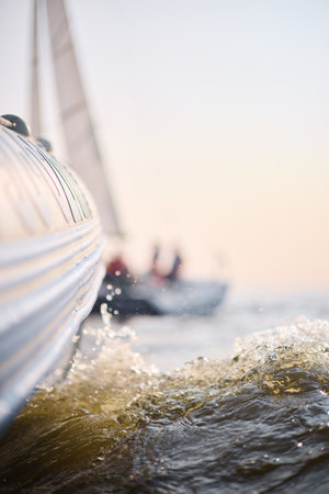 Sailing regatta in the Gulf of Finland at sunset, sailing yacht competing in a race, splashing water from under the boat, teamwork, board the boatの写真素材