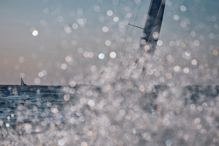 Sailing regatta in the Gulf of Finland at sunset, sailing yacht competing in a race, splashing water from under the boat, teamwork, board the boatの写真素材