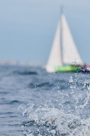 Sailing regatta in the Gulf of Finland at sunset, sailing yacht competing in a race, splashing water from under the boat, teamwork, board the boatの写真素材