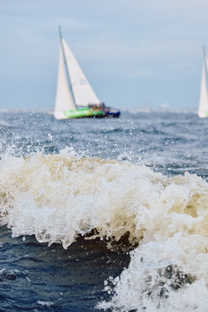 Sailing regatta in the Gulf of Finland at sunset, sailing yacht competing in a race, splashing water from under the boat, teamwork, board the boatの写真素材