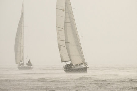 Sailing regatta in the Gulf of Finland in rain, few sailing yachts competing in a race, splashing water from under the boats, teamworkの写真素材