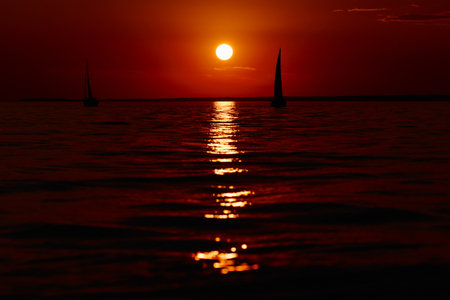 Sailing regatta in the Gulf of Finland at sunset, few sailing yachts competing in a race, splashing water from under the boats, teamworkの写真素材