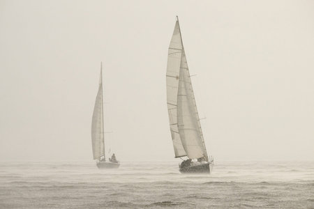 Sailing regatta in the Gulf of Finland in heavily rain, few sailing yachts competing in a race,...