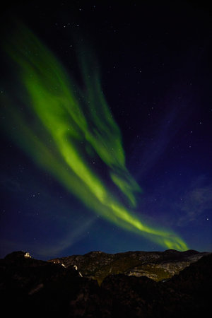 Aurora borealis over ocean in Teriberka, Russia, Murmansk region, Northern lights, Starry sky with...