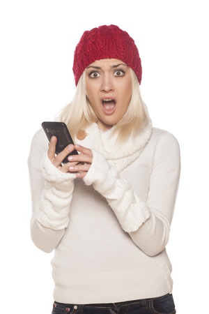 shocked girl with red hat reading a text message on white backgroundの写真素材