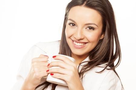 beautiful brunette in a white men s shirt drinking morning teaの写真素材